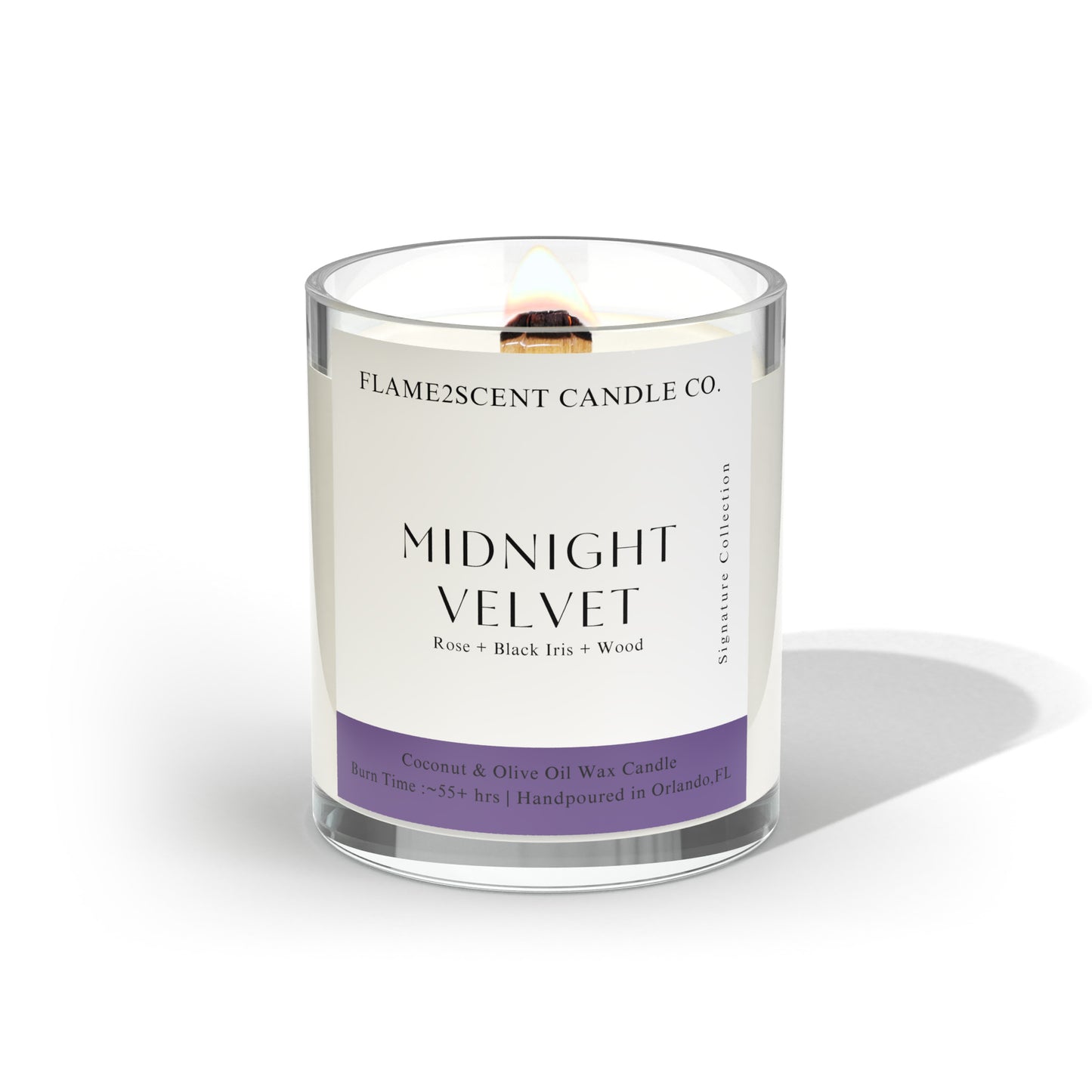 Midnight Velvet coconut wax candle with purple label, lit wood wick, and floral notes