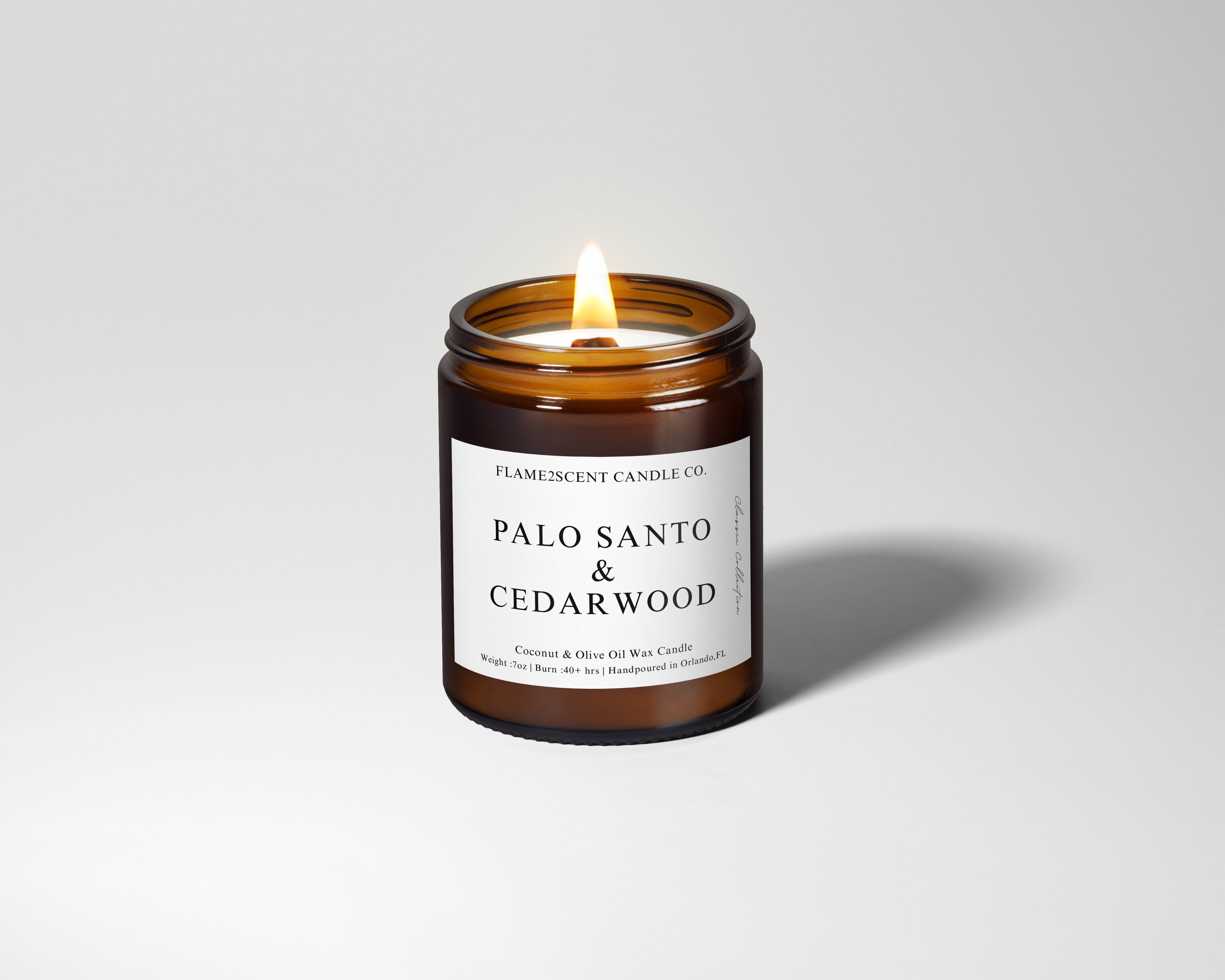 palo santo and cedarwood scented woodwick candle in amber glass jar with black lid