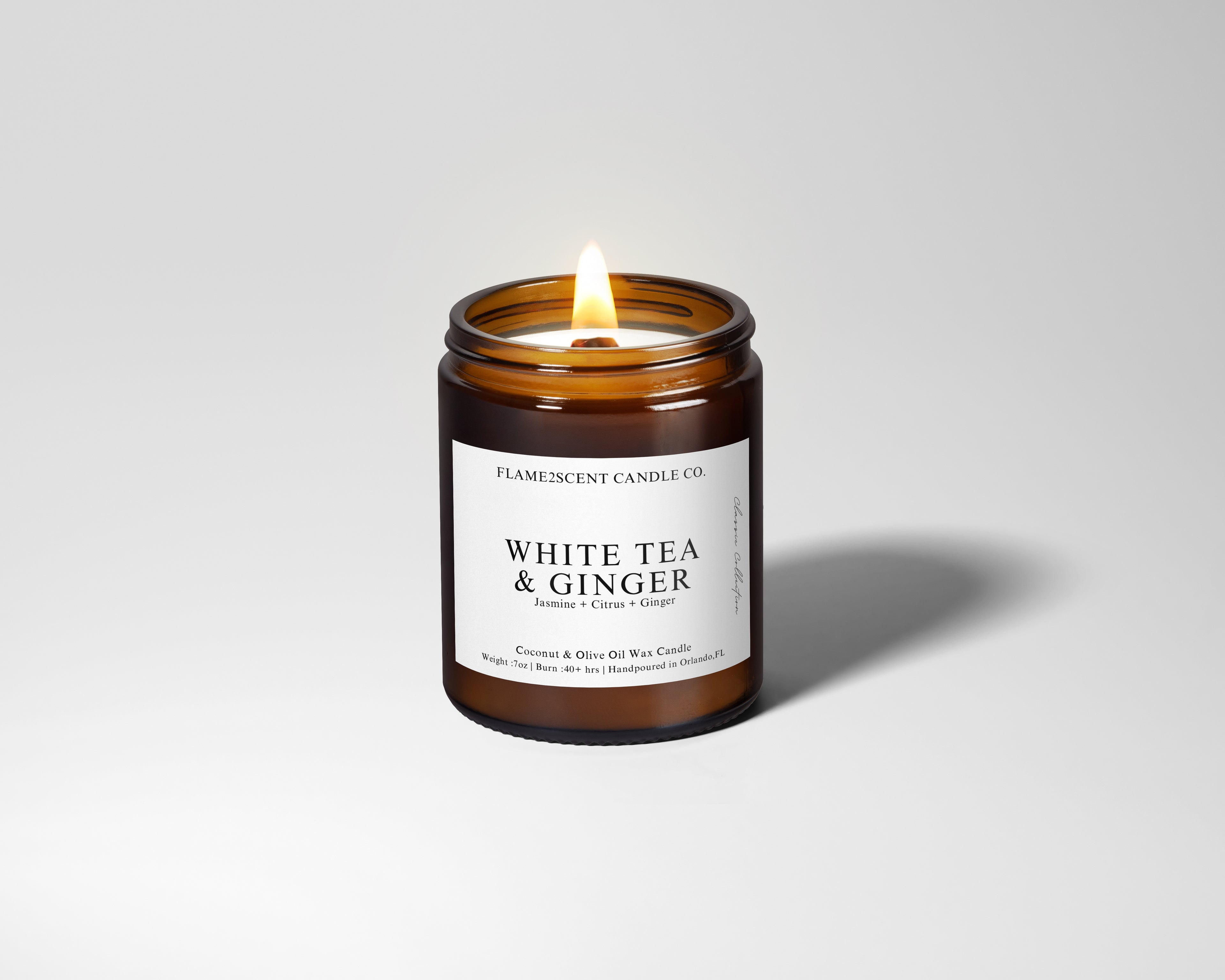 white tea candle in amber glass jar with wood ick and black lid