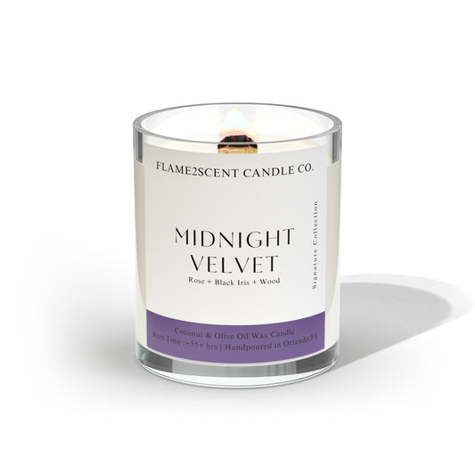 Midnight Velvet coconut wax candle with purple label, lit wood wick, and floral notes