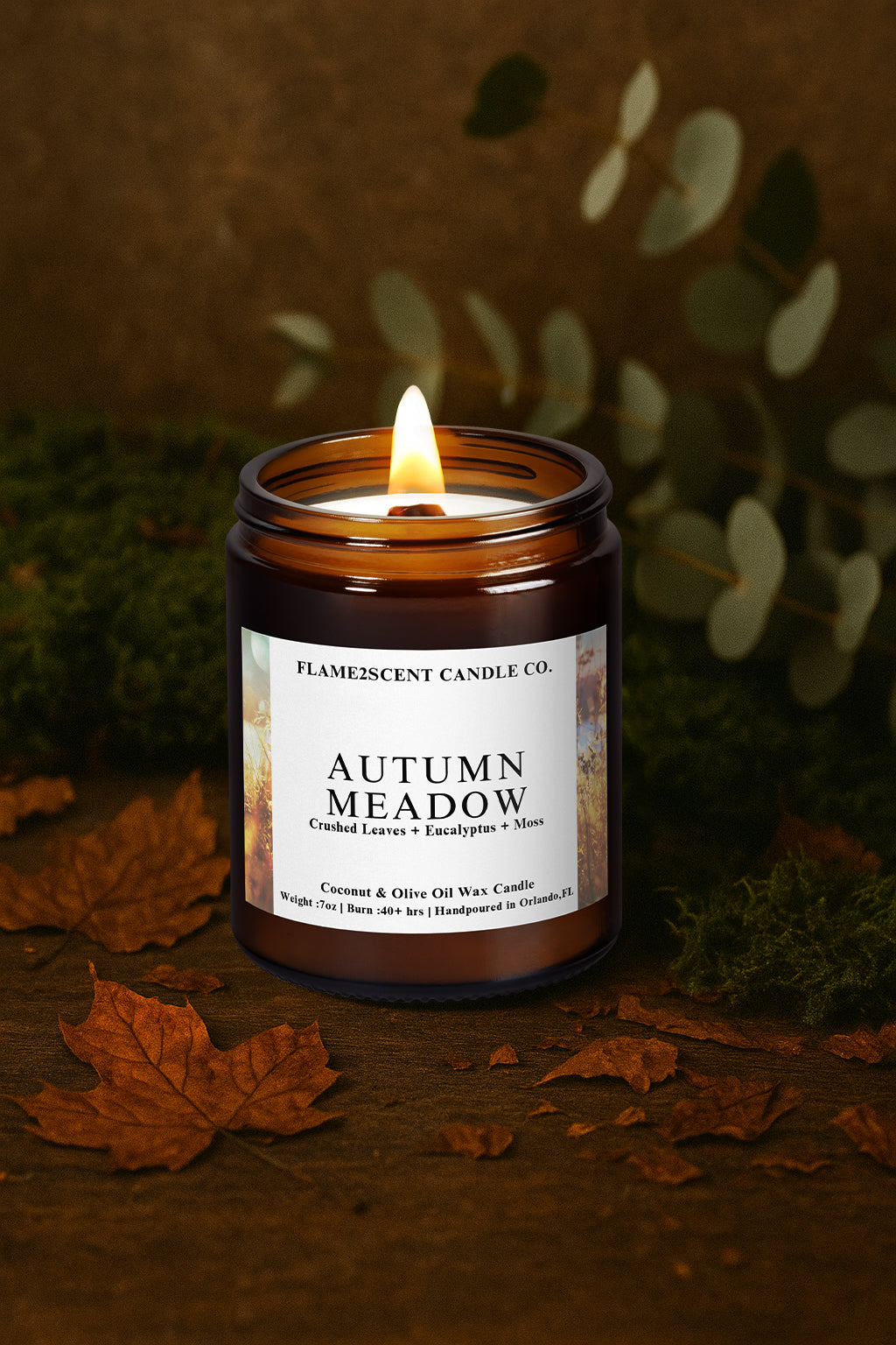 Candle labeled 'Autumn Meadow' from Flamescent Candle Co. on a dark background with leaves.