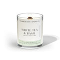 clean burning white tea and basil  scented coconut apricot wood wick candle in clear glass jar with black lid